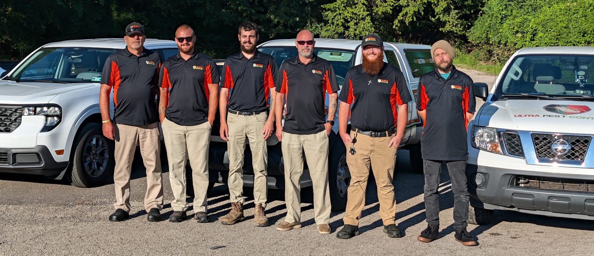 The Ultra Pest Control team standing together in front of their service trucks in Huntington, WV