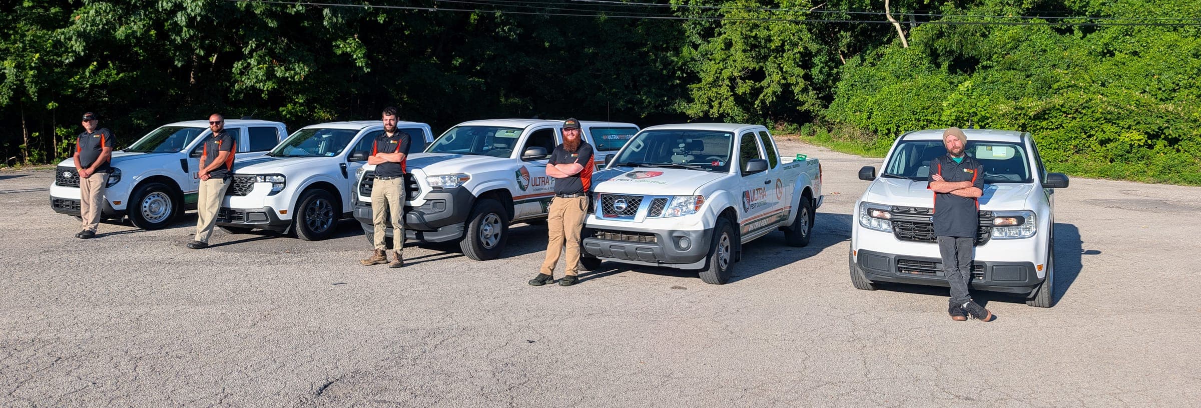 Ultra Pest Control technicians standing beside their branded service trucks in Huntington, WV
